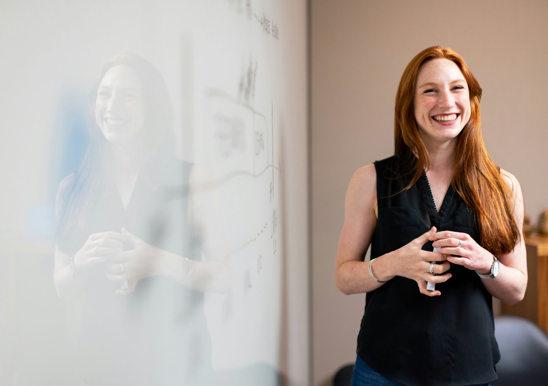 Smiling teacher leading a phone-free lesson at a whiteboard